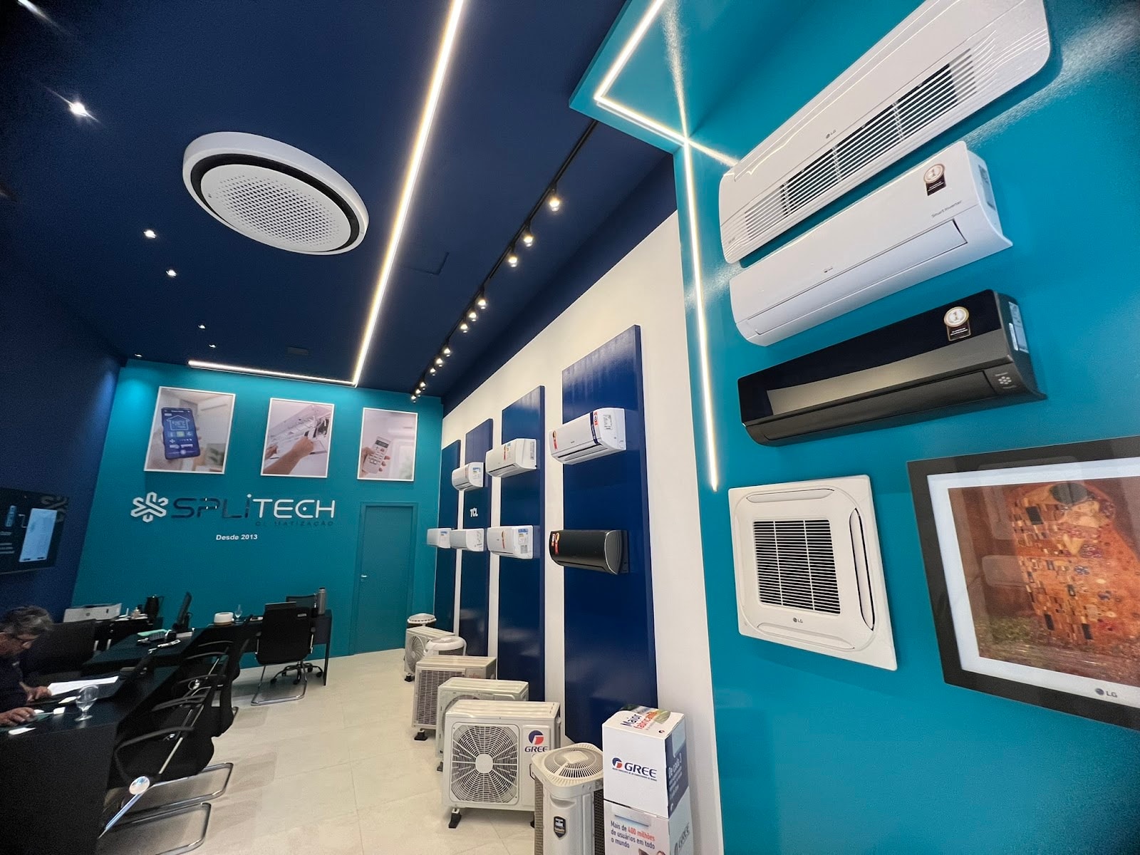 Showroom da Splitech em Meia Praia, com logo Desde 2013 na parede, equipamentos expostos e equipe atendendo